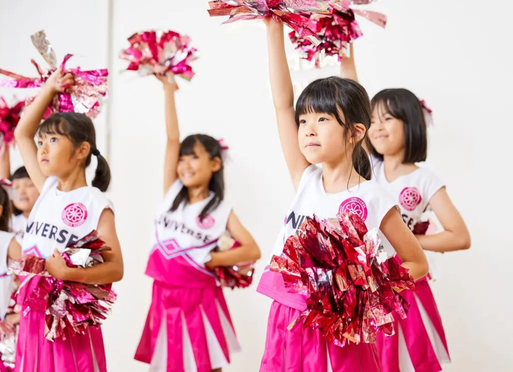 ユニフォームを着てポンポンを持つ子どもたち